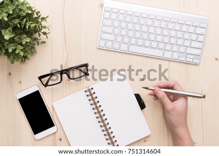 Man write on notebook  Modern  office desk with laptop and other supplies with cup of coffee
for input the text on copy space Top view, flat lay.