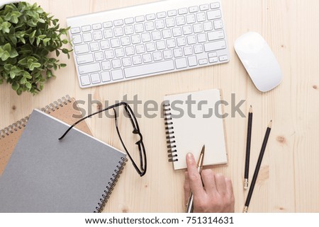 Man write on notebook  Modern  office desk with laptop and other supplies with cup of coffee
for input the text on copy space Top view, flat lay.