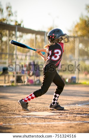 Child playing softball or baseball game