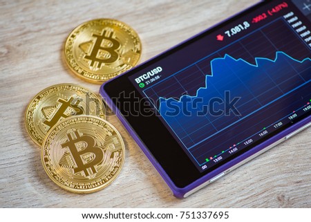 Golden bitcoin and smartohone on wooden background. Cryptocurrency concept Royalty-Free Stock Photo #751337695
