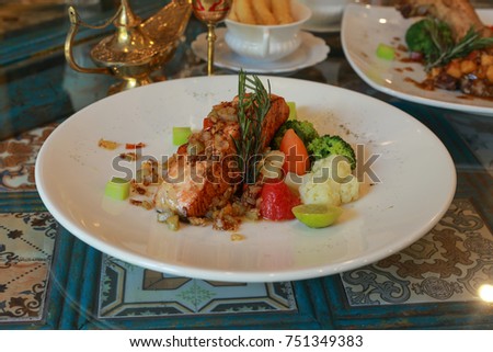 Salmon steck on the dish on wood table background, cloce up and decorated.