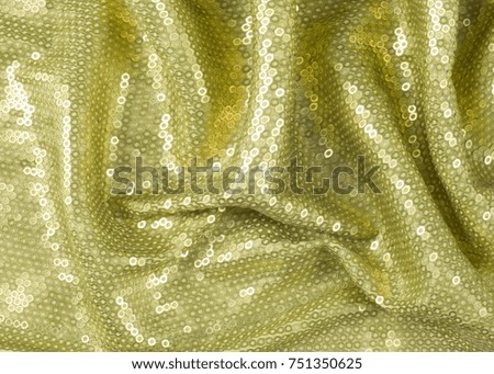 Fabric texture with green sequins. a small, shiny disk sewn as one of many onto clothing for decoration