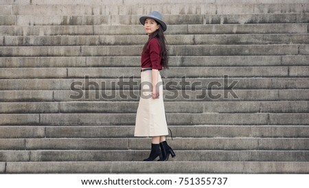 Beautiful Chinese woman stand with steps background, full length portrait.