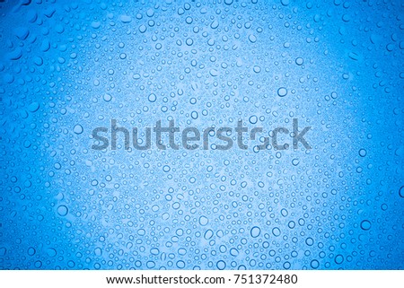 Rain droplets on blue glass background, Water drops on glass.
