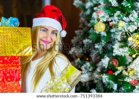beautiful plus size girl holding christmas gifts on the background of a Christmas tree