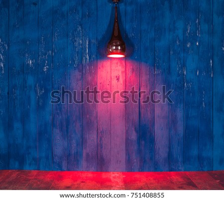 red light spotlight on a blue wooden wall