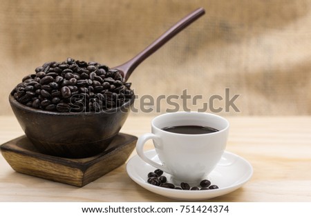 coffee cup and coffee beans in wooden cup.
