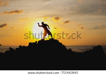 shadow of a man on the rock in ocean  with sunset  
