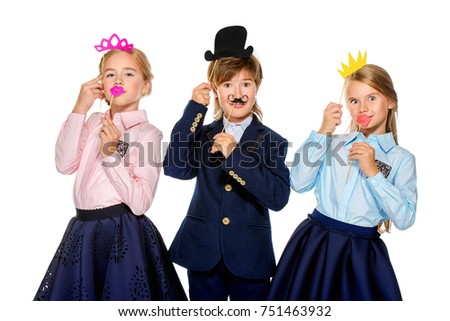 School, educational concept. Three joyful children in school uniform posing at studio with different masks. Isolated over white background. Copy space. 