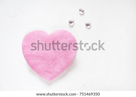 Flat lay of fabric heart and pink candles on white concrete background. Love concept.