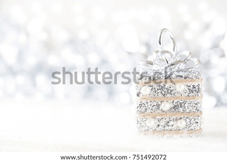 Silver and white Christmas decorations on white snow background. Space for text. Selective focus