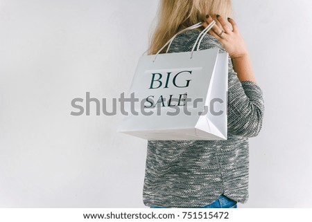 woman holding a paper bag with the sale sign