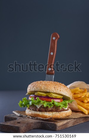 burger with pork chop and fries on a gray background, concept of fast food
