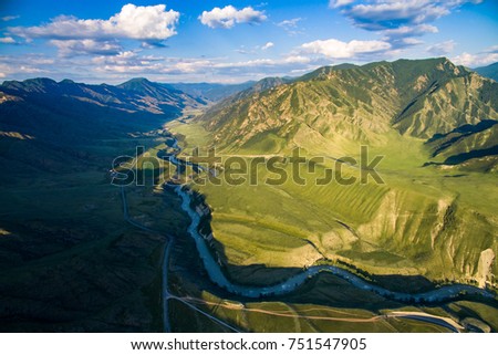 Aerial shot of the river among the green mountains