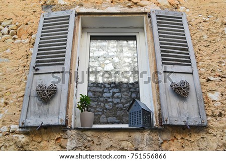 Rustic wooden window on a stone wall in France