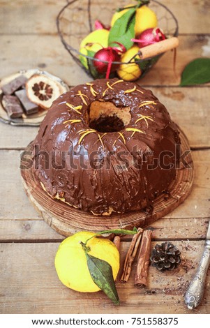 Delicious homemade chocolate orange cake with chocolate ganache on top. Christmas decoration, holiday mood. Wooden background, top view. 
