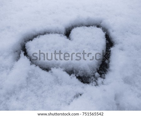 hand drawn heart shape in the fresh snow