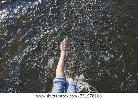 Splashing water by feet on warm summer day. View from above. Focused to water surface. View from above.