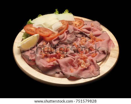 roastbeef with tomatoes on a wood dish