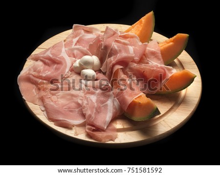 ham and melonon a wood dish