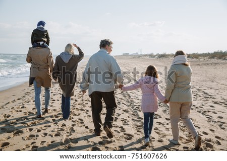back view of big multigenerational family walking together on seashore Royalty-Free Stock Photo #751607626