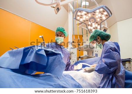 The medical team is operating a patient at the modern operating room.
