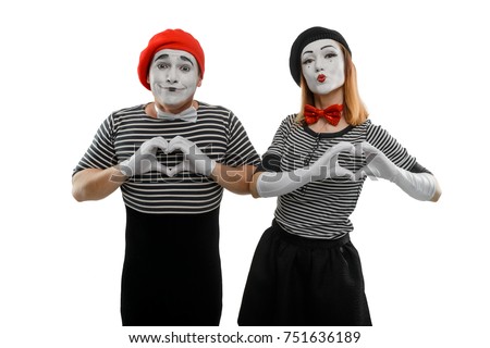 Mimes making a heart shape with their hands. Man and woman, dressed in scenic costume, are showing love sign and pursing lips to imitate kiss.