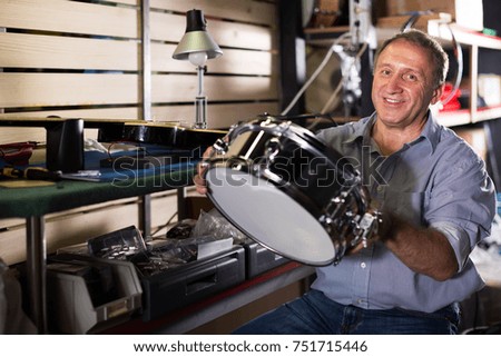 Man is repairing instruments in workshop.