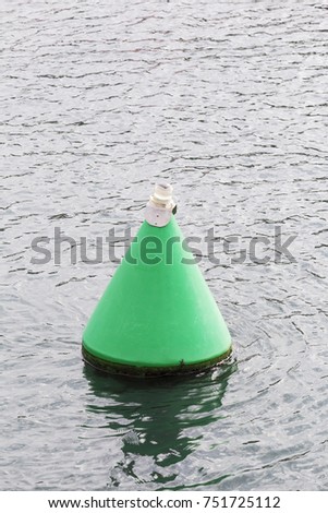 green safety mark buoy at the entrance to a seaport
