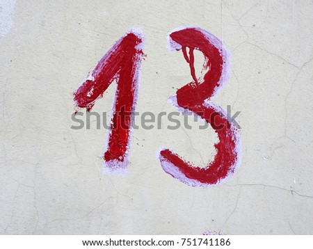 Number thirteen (red numbers on a white wall).