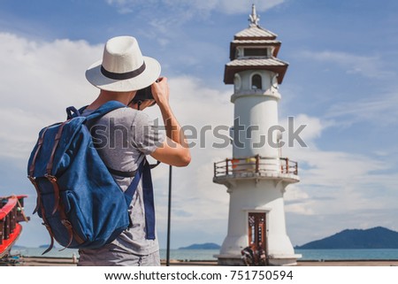 tourist photographer taking photo of lighthouse, travel photography