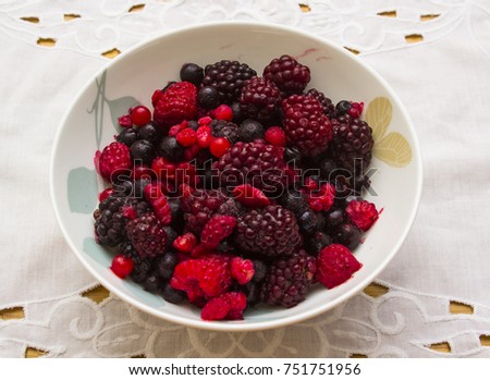 Mixed fruit berries defrosting in a bone china breakfast dish