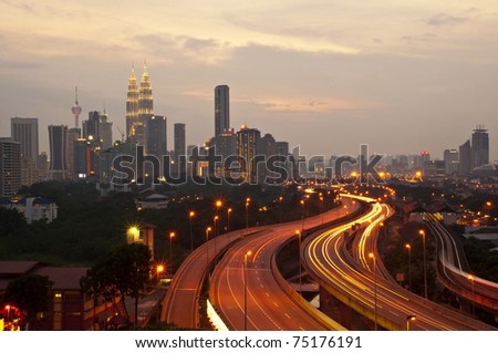 This scenario Kuala Lumpur twin towers, taken with slow shutter speed to get the light trail from the highway traffic in the evening. lightrail view of Kuala Lumpur city.