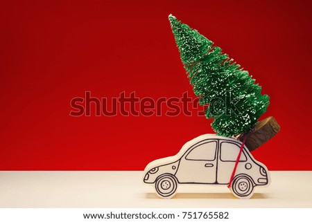 Christmas holiday concept with a small pine tree on handmade cartoon toy car - image with copy space