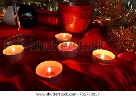 Candle dear cup red wine on table red light 