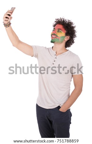 Happy guy taking selfie of his funny face paint. Isolated on white background.