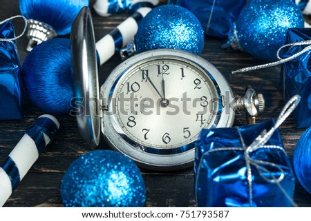 Old clock on wooden background with christmas balls, top view