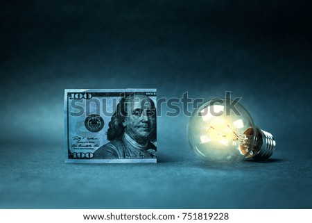 Hundred dollar and light bulb. Concept of idea and wealth.