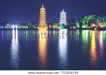 Guilin Sun and Moon Tower Pagodas in Fir Lake at night, color toned picture, China