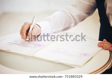 Groom puts the Signature in the Palace of Marriage Royalty-Free Stock Photo #751883329