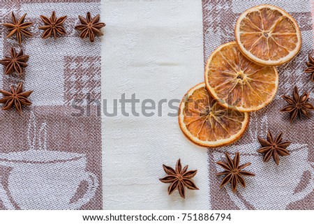 Anis, slices oranges lie on white and brown tablecloth