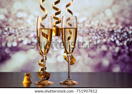two champagne glasses with ribbons against holiday lights and fireworks - New Year celebrations