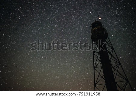 Silhouette of the Old Lighthouse against the background of the starry sky.