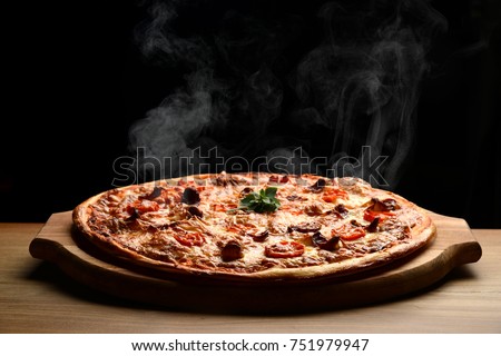 Hot big pepperoni pizza tasty pizza composition with melting cheese bacon tomatoes ham paprika steam smoke on black background