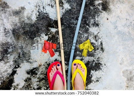 Walking Arrows Directions Drawn. Woman Wear Flip Flop Red and Yellow Standing on Cement Background Great for Any Use.