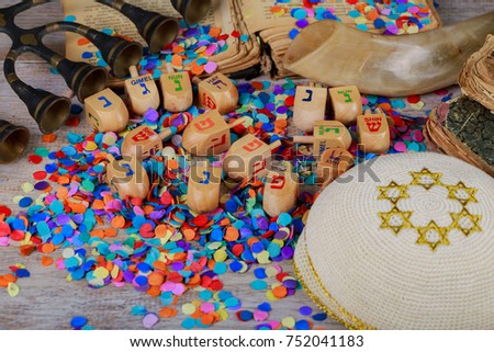 Chanukah wooden dreidels on a wood surface. Side view with the Hebrew letters nun, gimel, hey, shin. Shallow depth of field, drop shadow.