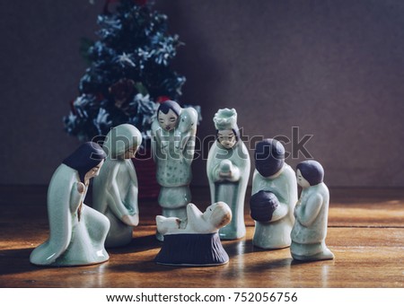 ceramic model of Mary and Joseph , wise man, Shepherd worship baby Jesus Christ in front of the Christmas tree over brown background Show christian concept Jesus is the reason of season