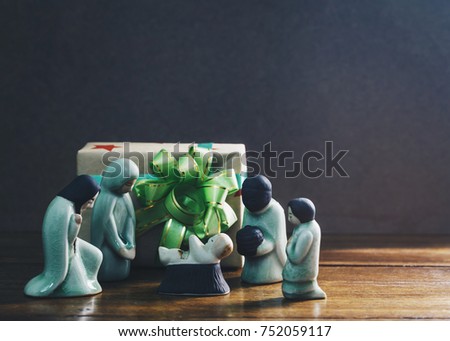 ceramic model of Mary and Joseph ,wise man and shepherd worship baby Jesus Christ in front of gift box over brown background Show christian concept Jesus is the gift from God for the world, copy space