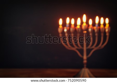 Abstract blurred image of jewish holiday Hanukkah background with menorah (traditional candelabra) and burning candles