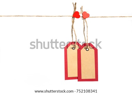 Two red and brown paper tags hanging on the rope by heart shape pin with copy space isolated on white background. St.Valentines gift concept.
